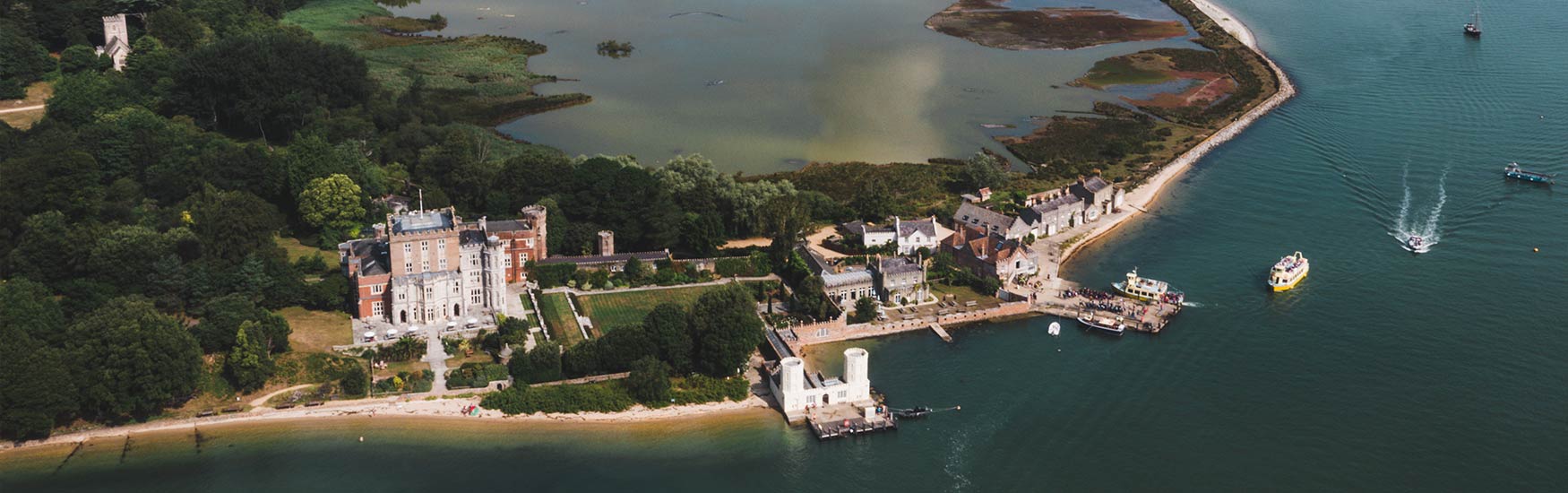 Aerial view of Brownsea island house and boats coming into land 