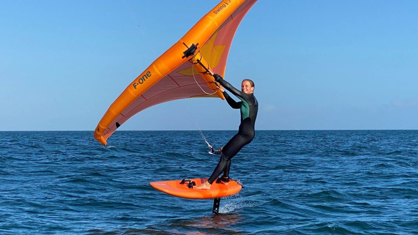 Woman enjoys wingfoiling on the waters surrounding Poole 